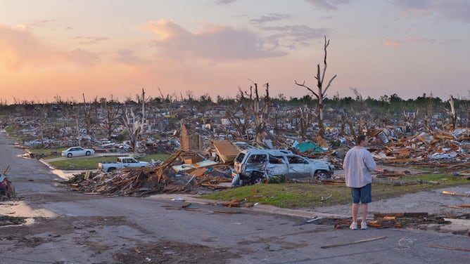 A person surveys damage one day after a tornado tore through Joplin, Missouri on May 23, 2011.