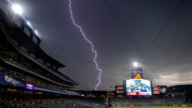 Lightning strikes behind Coors Field during a rain delay before a baseball game between the Cincinnati Reds and the Colorado Rockies on July 13, 2019 in Denver, Colorado.