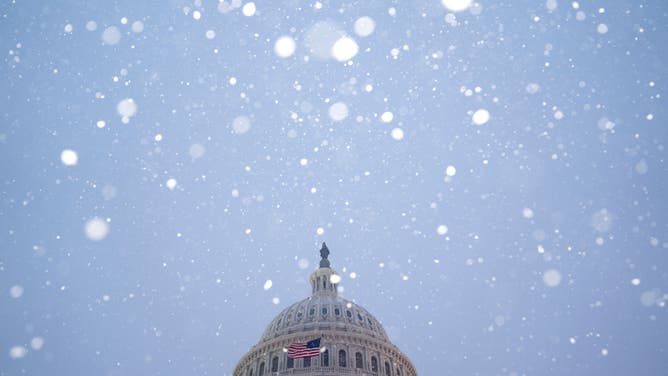 Snow falls around the U.S. Capitol Building.