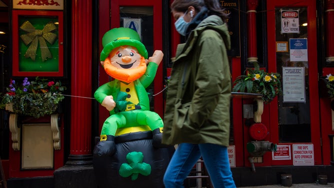 An inflatable leprechaun greets a passerby.