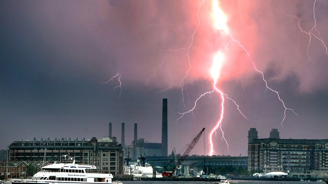 Boats quickly head to port as lightning from a series of thunderstorms strikes over and beyond Boston, Massachusetts.