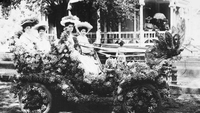 Four young ladies in flower decorated car for the Floral Parade at Mobile's Mardi Gras in 1905.
