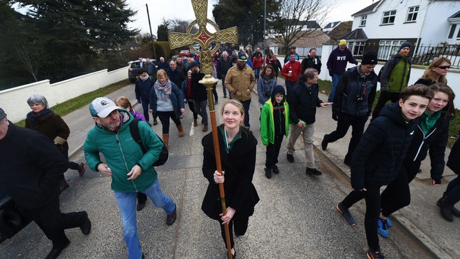 Church goers take turns in carrying a staff representing Saint Patrick during the annual Saint Patrick's Day service and pilgrimage from Saul church to Downpatrick cathedral on March 17, 2016 in Downpatrick, Northern Ireland. St. Patrick is believed to be buried at Saul church.