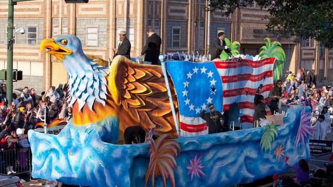 A patriotic float moves down the street during Mardi Gras in Mobile.