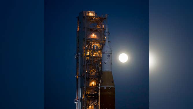 The Moon is seen rising behind NASA’s Space Launch System (SLS) rocket with the Orion spacecraft aboard atop a mobile launcher as it rolls out to Launch Complex 39B for the first time, Thursday, March 17, 2022, at NASA’s Kennedy Space Center in Florida. Ahead of NASA’s Artemis I flight test, the fully stacked and integrated SLS rocket and Orion spacecraft will undergo a wet dress rehearsal at Launch Complex 39B to verify systems and practice countdown procedures for the first launch. Photo Credit: (NASA/Aubrey Gemignani)