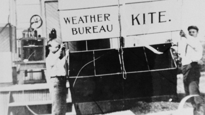 Two men prepare to launch a Weather Bureau kite. The Weather Bureau was created in the late 19th century, and its name was changed to the National Weather Service in 1970.