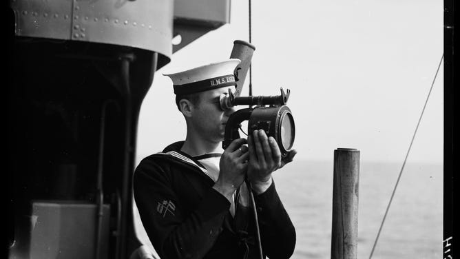 Example of a sailor using a signaling lamp.