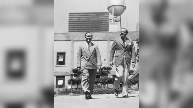 Arthur Freed (left) and Nacio Herb Brown (right) stroll on the MGM backlot circa 1935 in Culver City, California.