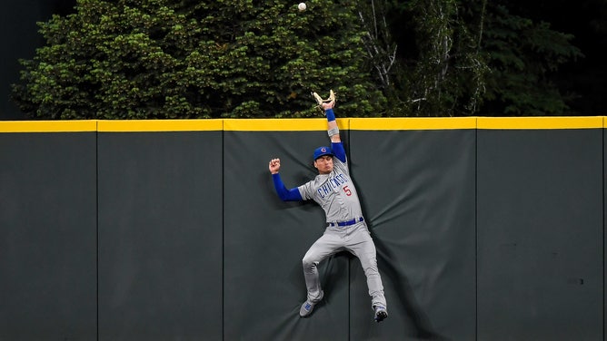 Chicago Cubs center fielder Albert Almora Jr. #5 leaps to attempt to catch a home run at Coors Field in Denver, Colorado. 