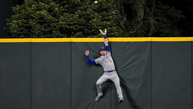 Chicago Cubs center fielder Albert Almora Jr. #5 leaps to attempt to catch a home run at Coors Field in Denver, Colorado.