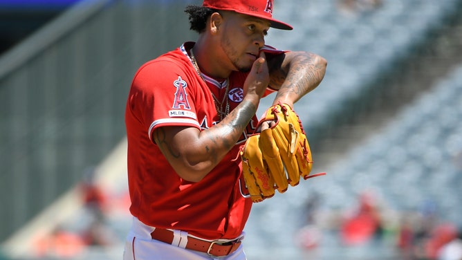 Felix Pena #64 of the Los Angeles Angels of Anaheim wipes the sweat from his face during a hot afternoon pitching on July 28, 2019 in Anaheim, California.