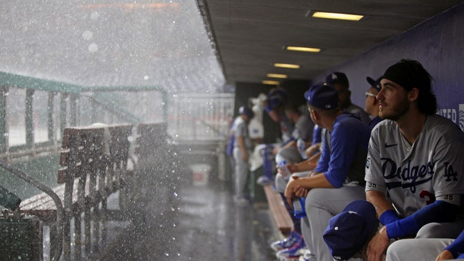 Members of the Los Angeles Dodgers look on from the dugout during a rain delay during the game between the Los Angeles Dodgers and the Philadelphia Phillies at Citizens Bank Park on Tuesday, August 10, 2021 in Philadelphia, Pennsylvania.