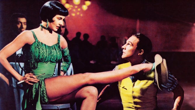 Rich colors paint the screen as Gene Kelly dances with actress Cyd Charisse in "Singin' in the Rain". By the time the film premiered, studios filmed their movies in color to pull audiences away from their black and white TVs.