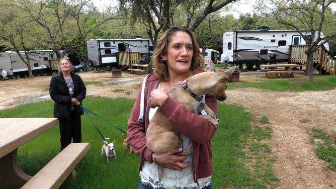 Camp fire survivors and now neighbors, Maureen Curtis, (left) with her dogs Buddy and Spark and Geneva Brockselsby, with Lulu get acquainted as they move into at the Bidwell Canyon State Campground on the shore of Lake Oroville, as seen on Mon. April. 15, 2019, in Oroville, Ca. FEMA has installed 69 trailers at the campground for Camp Fire survivors to use. (Photo By Michael Macor/The San Francisco Chronicle via Getty Images)