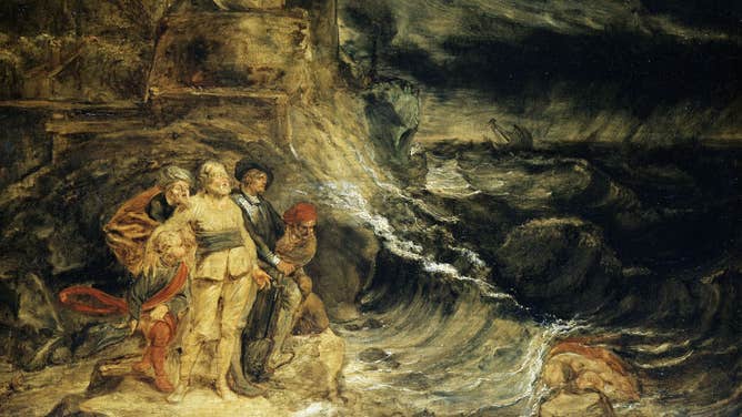 Waves crash upon the shore as King Lear stands defiantly in a storm.