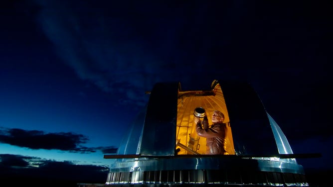 Perry Walker, a retired Air Force officer and amateur astronomer, adjusts the telescope in his self-made observatory before viewing the skies from his home in Wyoming.