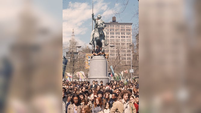 Crowds gather by a George Washington statue in Union Square for Earth Day celebrations, New York City, April 22, 1970.