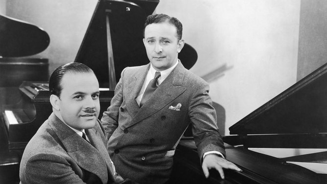 Nacio Herb Brown (left) and Arthur Freed (right) sit at a piano.