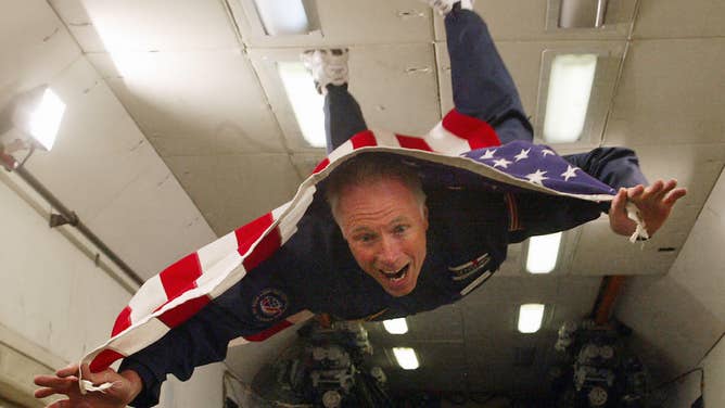 A space tourist floats inside a zero-gravity simulator.