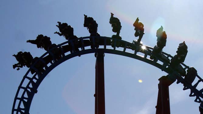 Amusement park goers with their feet in the air as a rollercoaster ride turns upside down.