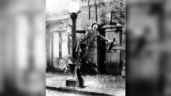 Gene Kelly performs song "Singin' in the Rain".