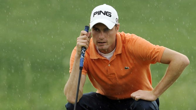Rhys Davies of Wales lines up a putt under the rain during the Round Four of the Volvo China Open on April 18, 2010 in Suzhou, China.