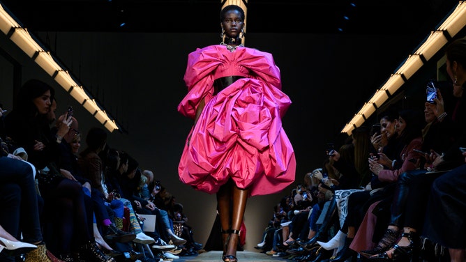 A model sports a hot pink outfit during Paris Fashion Week Fall 2019/Winter 2020.