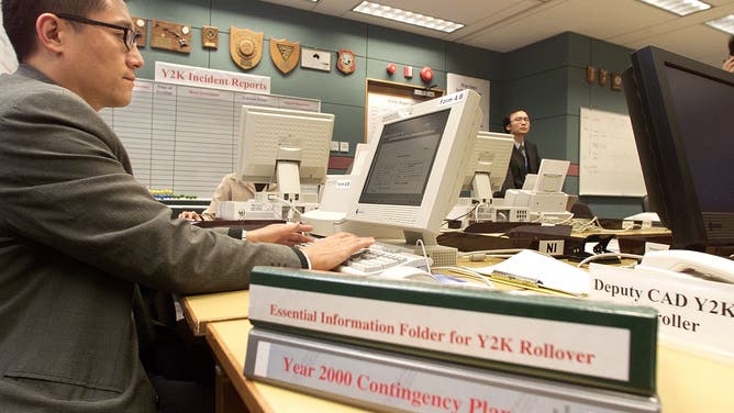 Y2K preparedness manuals lie next to an airport official checking computers in December 1999.