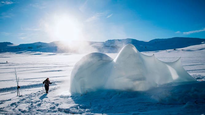 An organiser sprays water towards a structure of ice ahead of the Ice Music Festival on February 2, 2018 in the small mountain village of Finse in the municipality of Ulvik in southern Norway.?