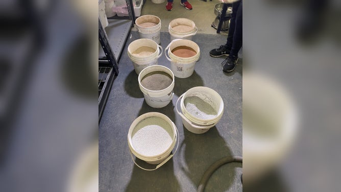 Buckets of Lunar Mare Simulant, Lunar Highland Simulant, moon dust and Mars simulant at UCF's Exolith Lab in Oviedo, Florida. The lab produces the simulated moon and Mars dirt for researchers and educators. (Image: Emilee Speck/FOX Weather)