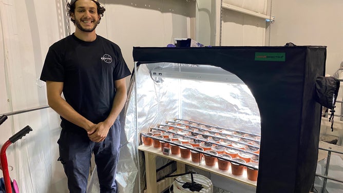 UCF biology major Steven Elsaid stands next to his greenhouse growing French Marigolds in lunar simulant at the Exolith Lab. (Image: Emilee Speck/FOX Weather)