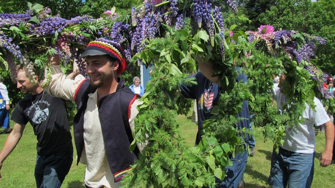 Men carry the Midsommer pole to the festival.