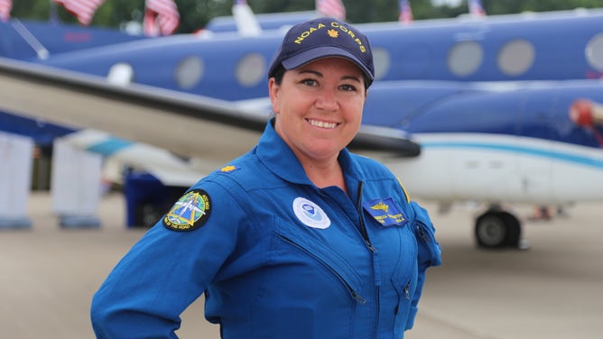 Commander Rebecca Waddington in 2016, with a King Air aircraft in the background.