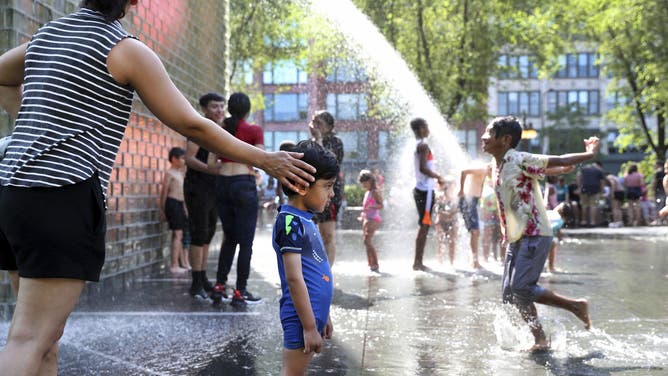 Anchal Khanna of Chicago's Lakeview neighborhood touches her son Veer Roy as the 2-year-old considers the landscape of Millennium Park's Crown Fountain during a heat wave on June 14, 2022. (Chris Sweda/Chicago Tribune/Tribune News Service via Getty Images)