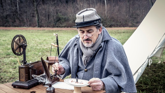 A participant reenacts the use of a telegraph during the Civil War.