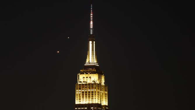 Planets Venus (left) and Jupiter rise together in the pre-dawn sky behind the Empire State Building in New York City on May 1, 2022, as seen from Hoboken, New Jersey. (Photo by Gary Hershorn/Getty Images)