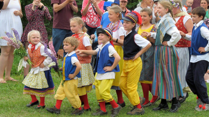 Children in traditional dress dance during Midsommer Festival 2018.