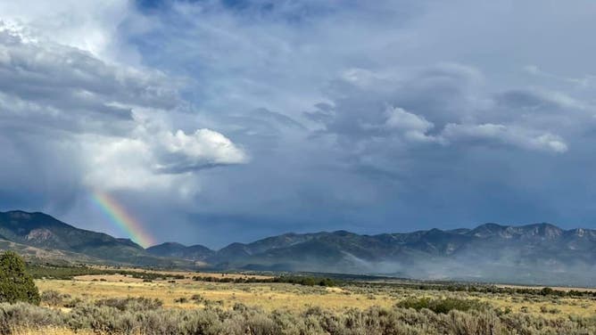 A rainbow and heavy cloud cover over the Halfway Hill wildfire in Utah.