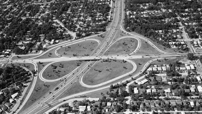Aerial shot of suburban neighborhoods growing along the highway, ca. 1960s.