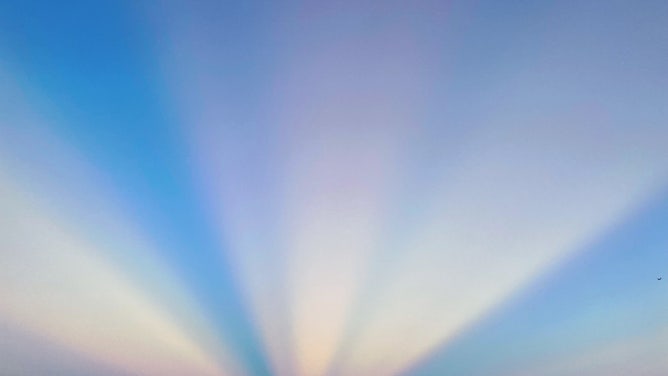 Anti crepuscular ray with rainbow color appears in the sky