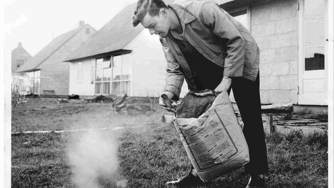 Homeowner Bill Duggan spreads fertilizer on the lawn of his property in Levittown, New York on April 18, 1950.