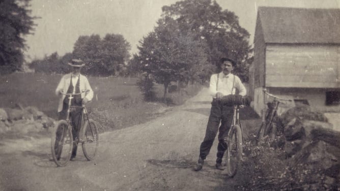 Two men and their bicycles in the late 19th century.
