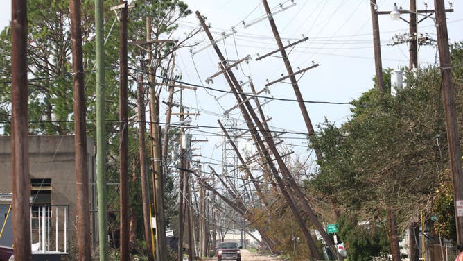 Utility poles lean over a street following Hurricane Ida on August 31, 2021 in Houma, Louisiana. Ida made landfall August 29 as a Category 4 storm southwest of New Orleans, causing widespread power outages, flooding and massive damage. (Photo by Scott Olson/Getty Images)