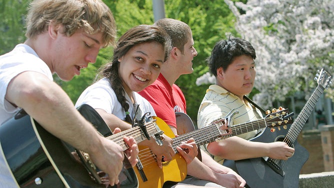 Boston University students play their guitars under the sun.