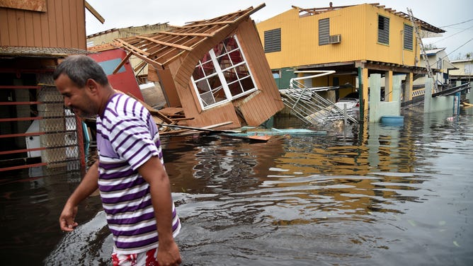 A man wades through deep floodwaters in Puerto Rico