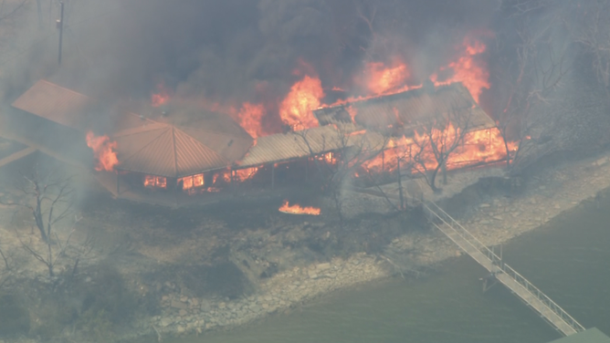 A wildfire burns a home near Possum Kingdom Lake in North Texas.
