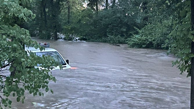 A van covered up to the windshield in flood water in Brentwood, Missouri on July 26, 2022.