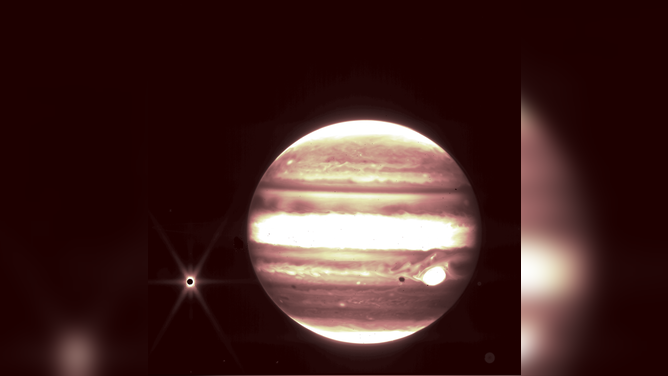 Jupiter, center, and its moon Europa, left, are seen through the James Webb Space Telescope’s NIRCam instrument.