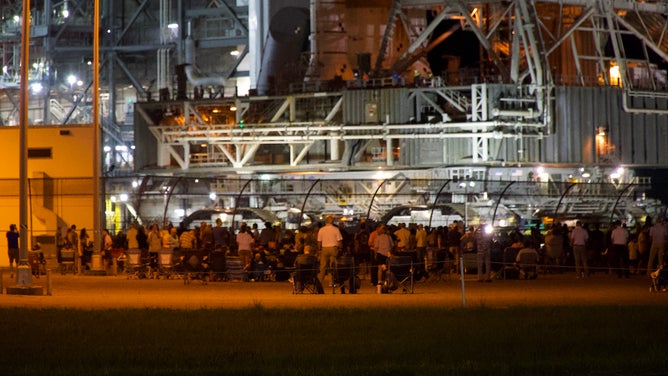 Spectators watch as NASA's Space Launch System rocket and Orion spacecraft make the journey to Kennedy Space Center launchpad 39B on Aug. 16, 2022.