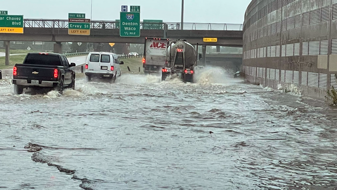 Vehicles drive across a water-covered highway in Dallas on Monday, August 23, 2023.
